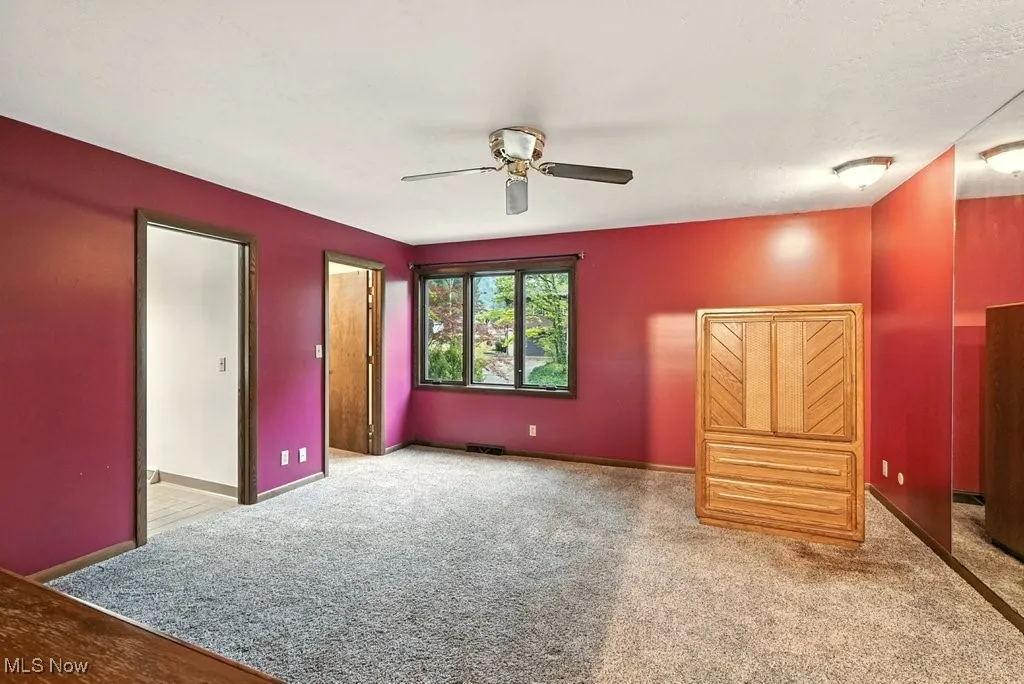 Unfurnished bedroom featuring ceiling fan and light carpet