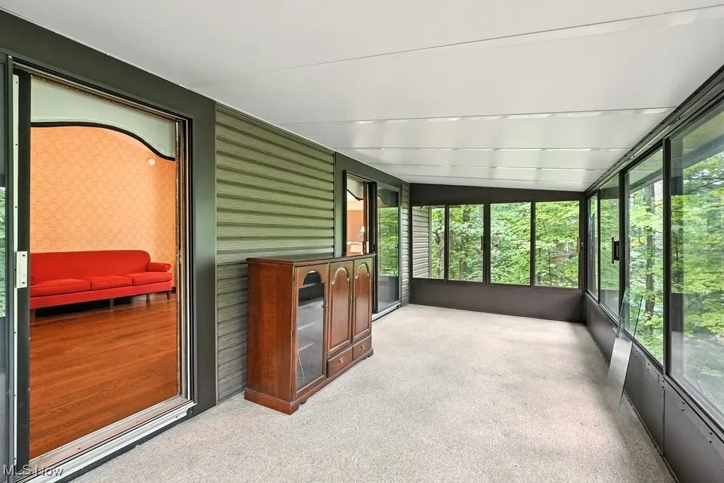 Unfurnished sunroom with lofted ceiling
