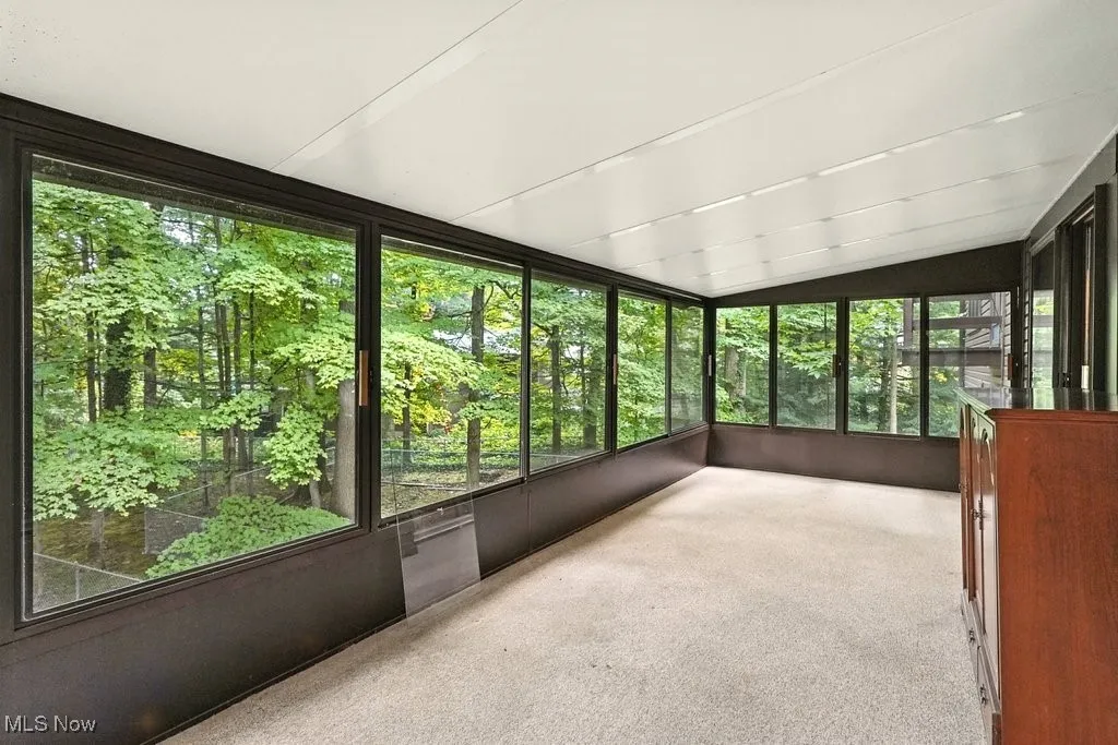 Unfurnished sunroom with lofted ceiling