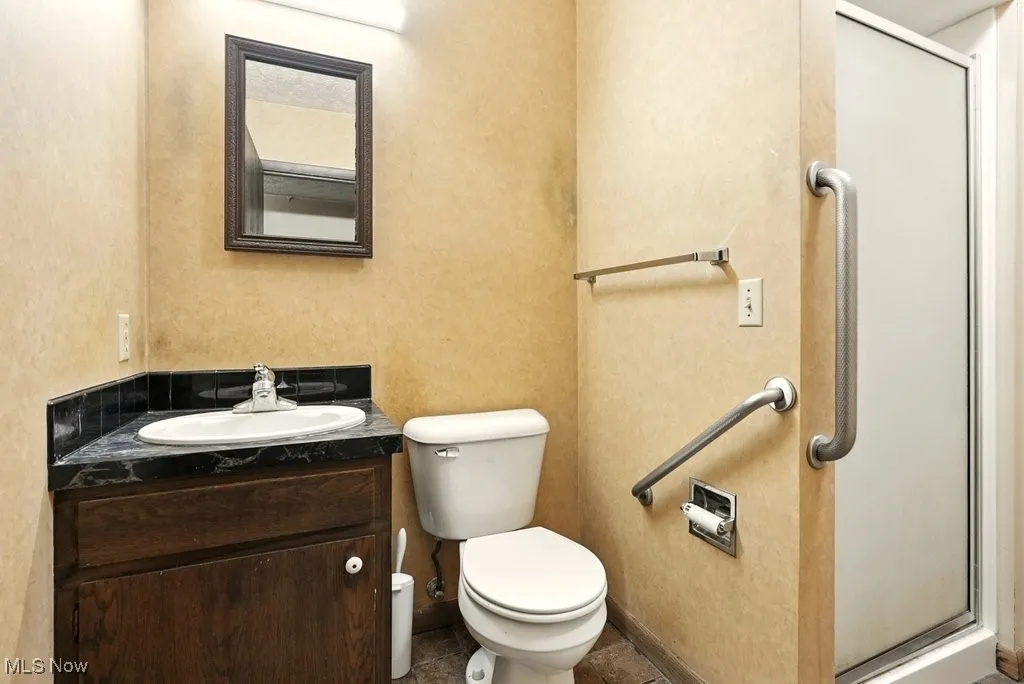 Full bathroom with vanity and a shower stall