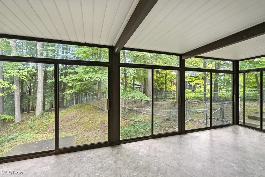 Unfurnished sunroom with beamed ceiling