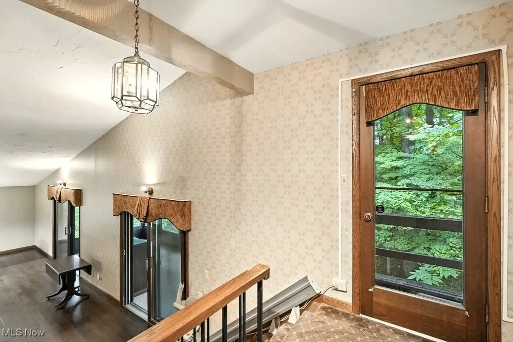 Stairway featuring beam ceiling and wood finished floors