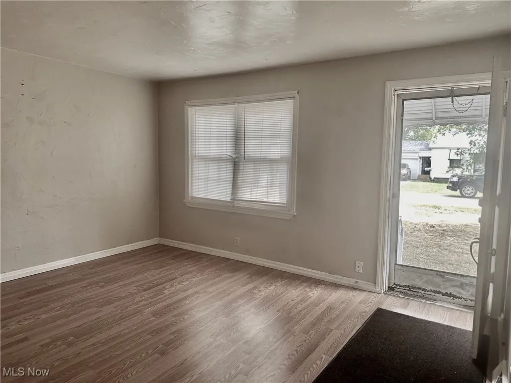 Living room with wood finished floors, plenty of natural light, and a textured ceiling