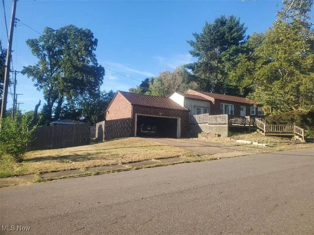 View of front facade featuring driveway and a deck