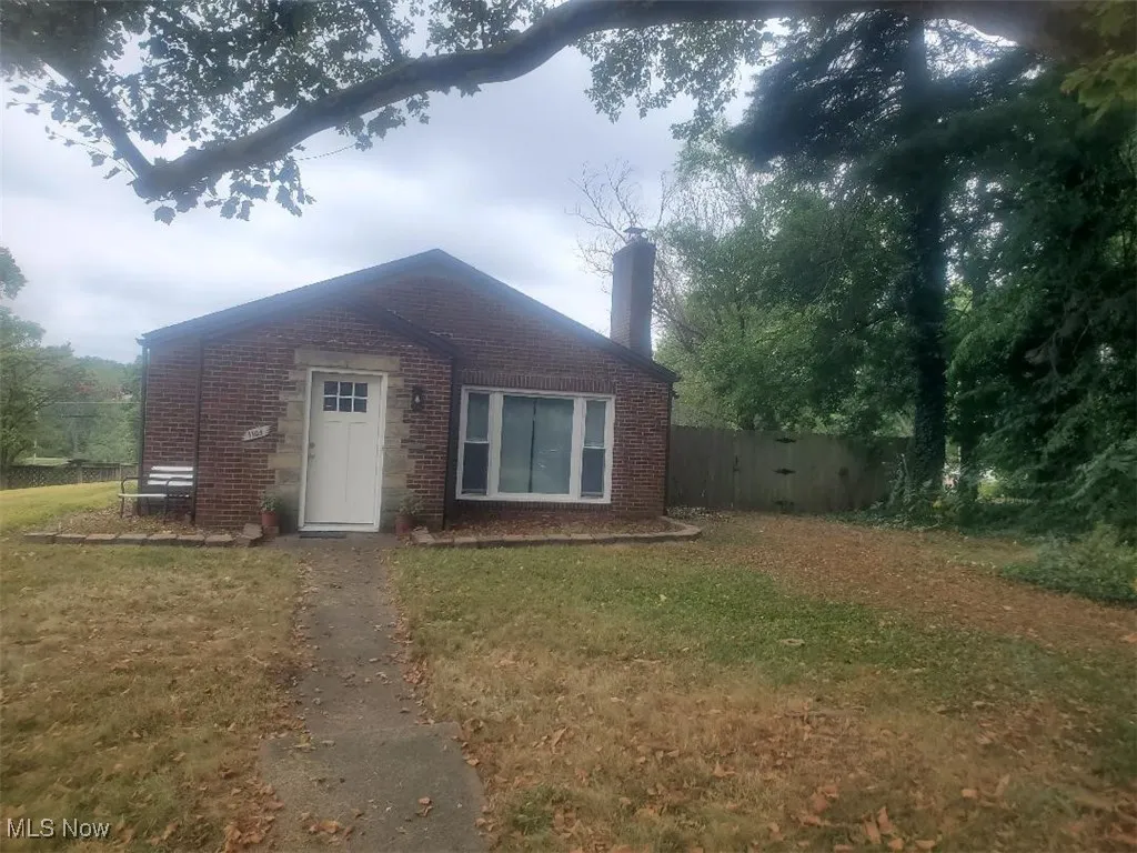 Bungalow-style house with brick siding and a chimney