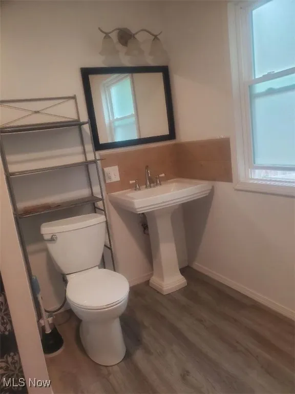 Half bathroom featuring dark wood-style flooring and plenty of natural light