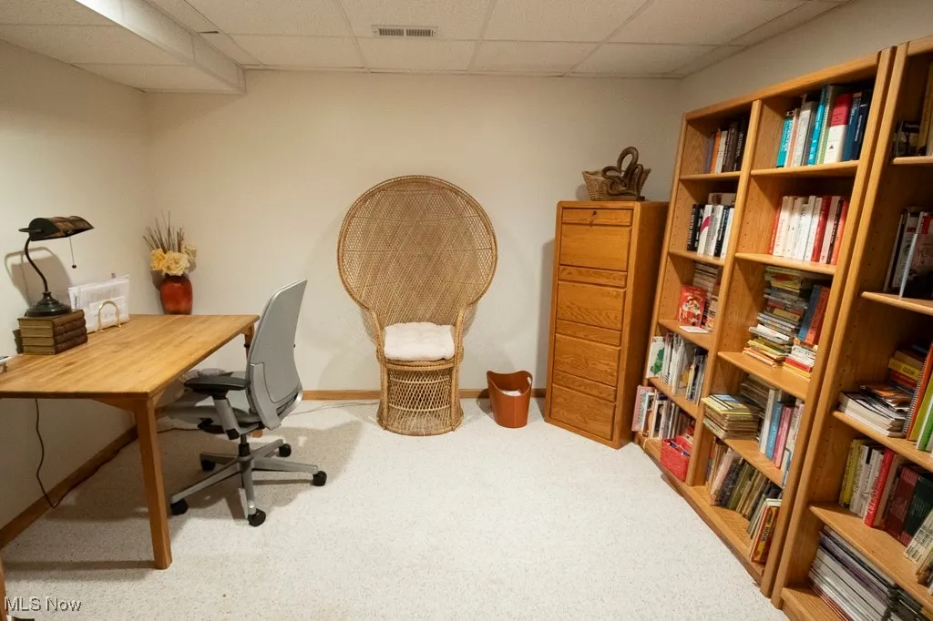 Office space with light carpet and a drop ceiling