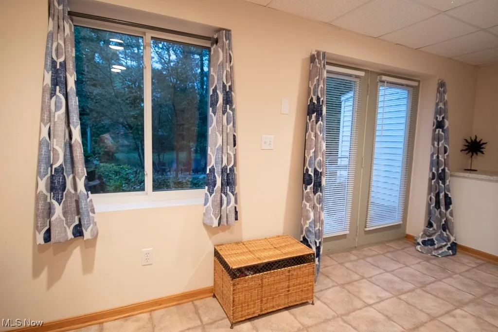 Foyer featuring a drop ceiling and baseboards