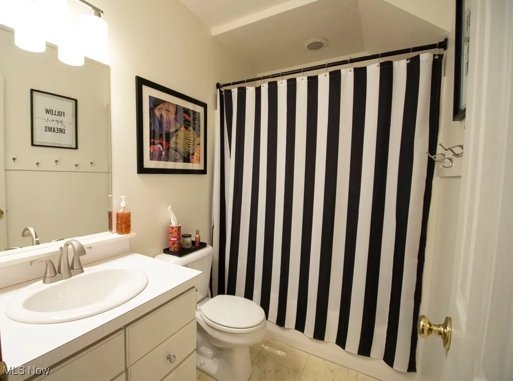 Full bath featuring vanity and curtained shower