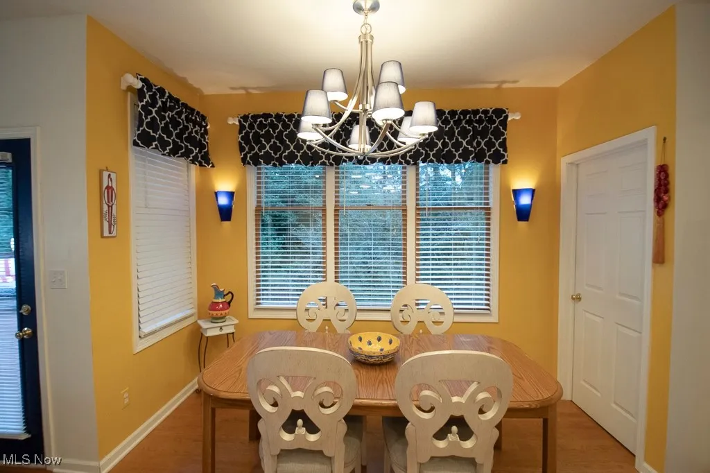 Dining area featuring wood finished floors and a chandelier