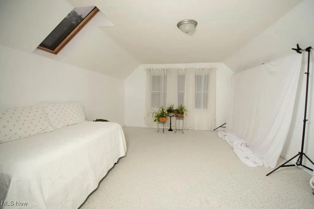 Carpeted bedroom with vaulted ceiling