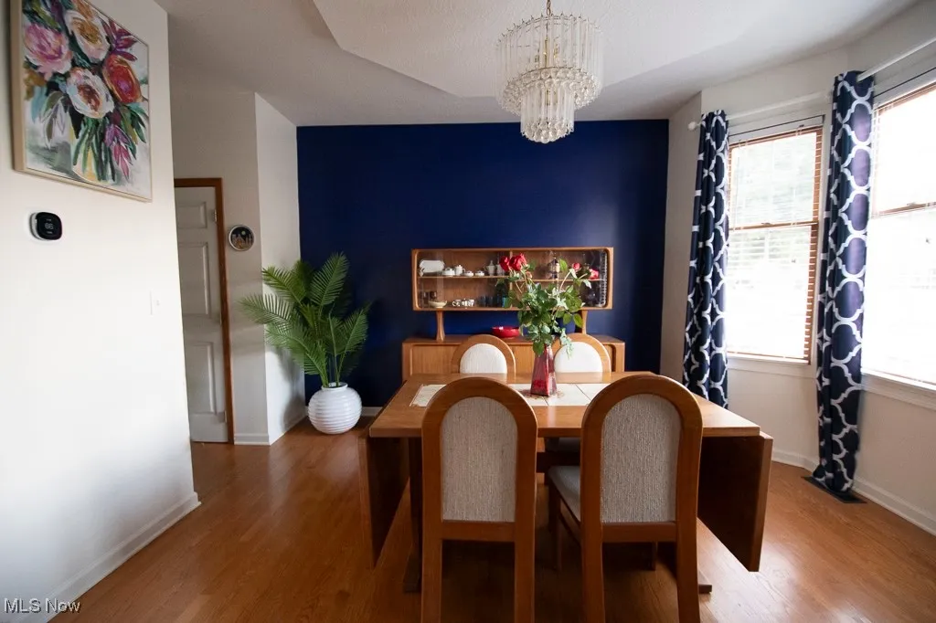 Dining space with wood finished floors and a chandelier