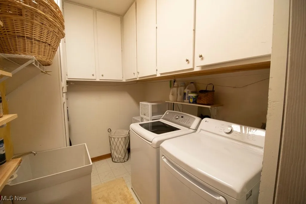 Laundry room featuring independent washer and dryer and cabinet space