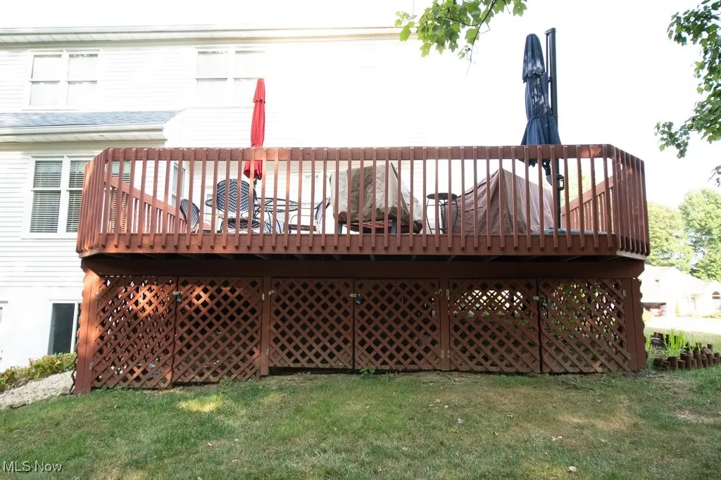 Rear view of property with a wooden deck and a yard