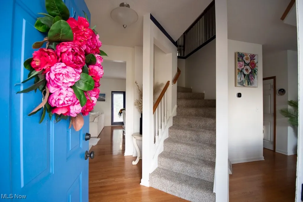 Entryway with wood finished floors and stairway