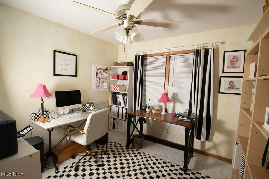 Office area with a ceiling fan and light flooring