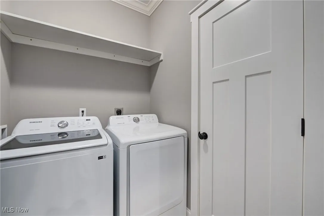 Laundry room with washing machine and dryer and ornamental molding