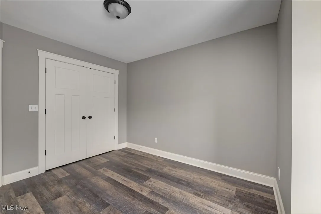 Foyer featuring baseboards and dark wood-type flooring