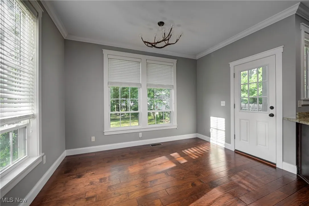 Entryway featuring ornamental molding, dark wood finished floors, and a chandelier