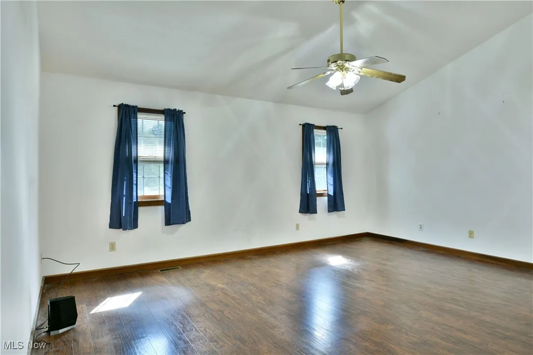 Empty room with wood finished floors and ceiling fan