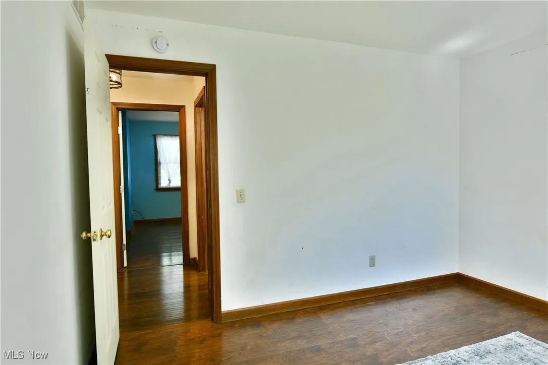 Spare room featuring dark wood-style floors