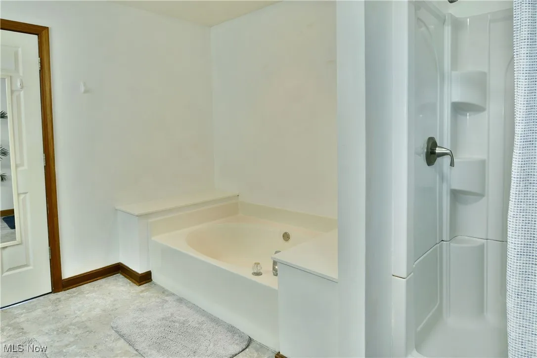 Bathroom with a shower stall and a bath