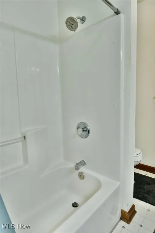 Full bath featuring shower / tub combination and light tile patterned flooring