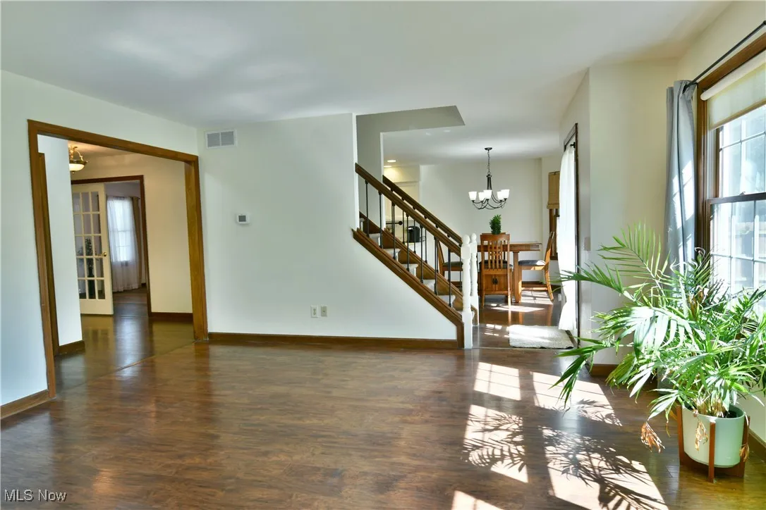 Living area with healthy amount of natural light and dark wood-style floors