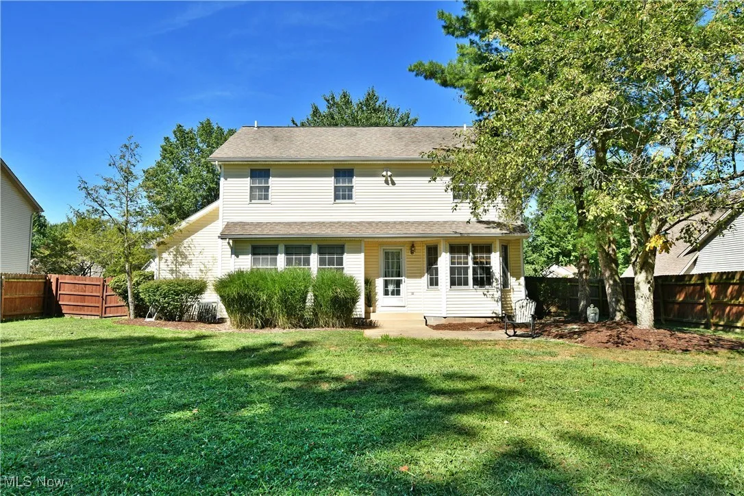 Rear view of property with a fenced backyard and a patio