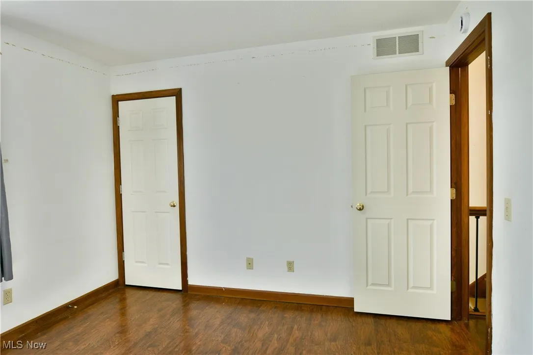 Unfurnished bedroom featuring dark wood-style floors