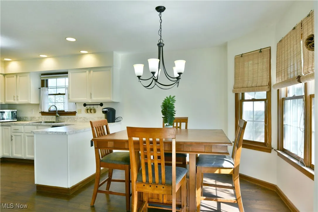 Dining room featuring a chandelier, dark wood finished floors, and recessed lighting