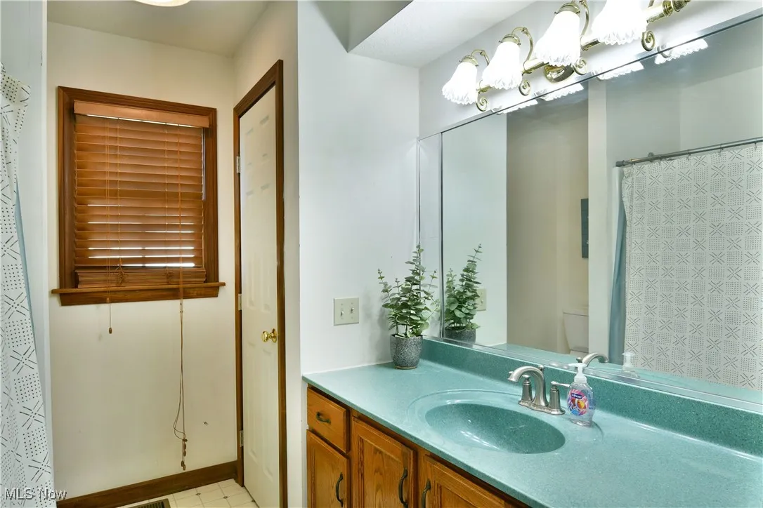 Full bath featuring vanity and light tile patterned floors