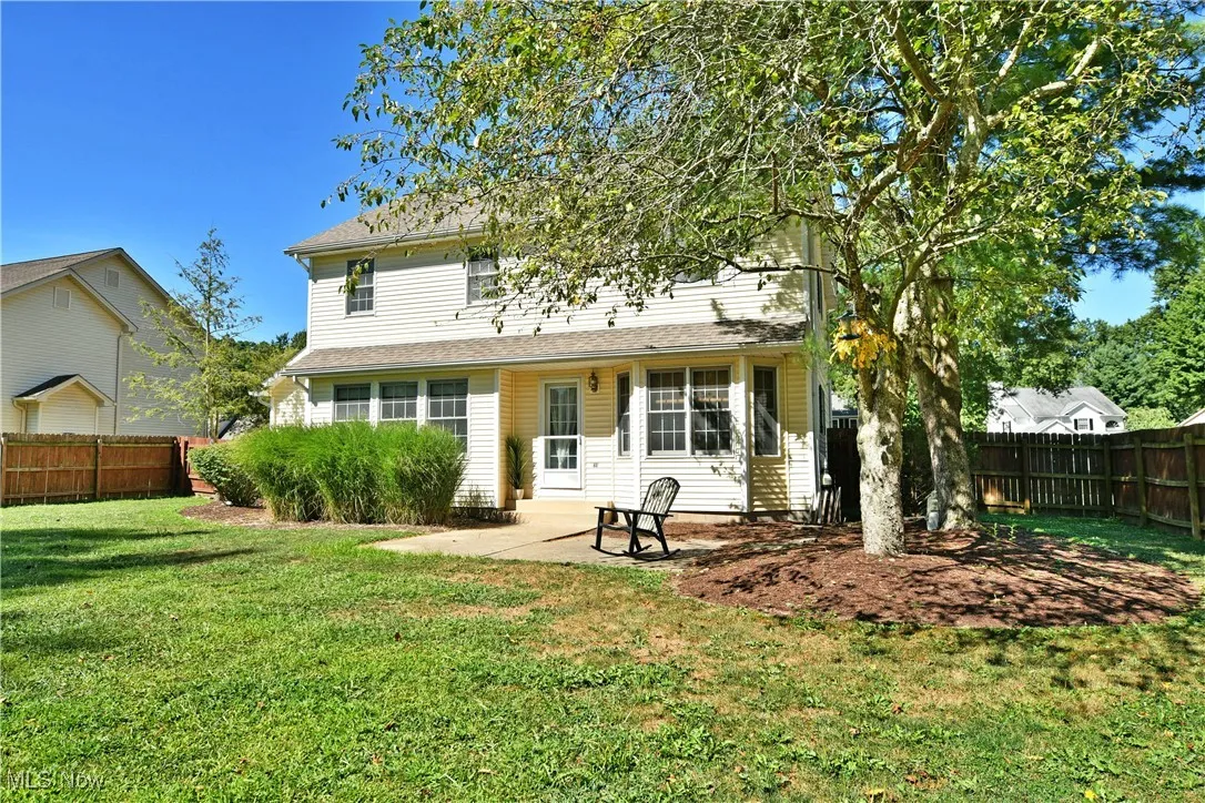 Rear view of house with a fenced backyard and a patio area