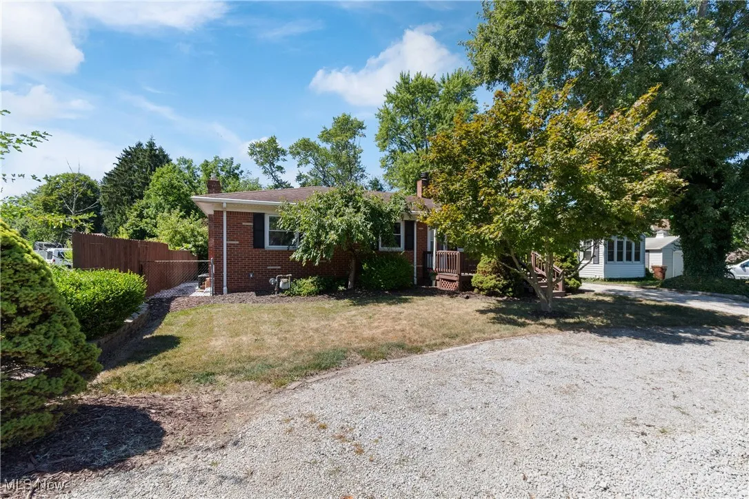 View of front of property featuring brick siding, a deck, and a chimney