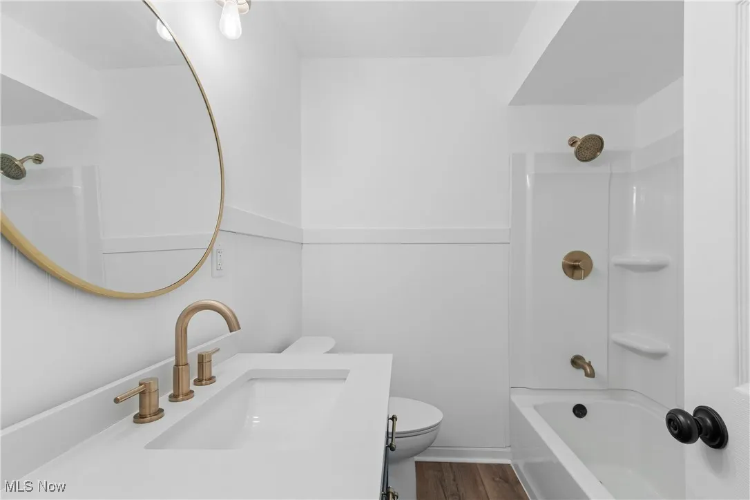 Bathroom with  shower combination, vanity, and dark wood-type flooring