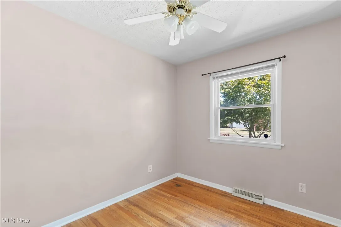 Empty room with light wood-type flooring and a textured ceiling