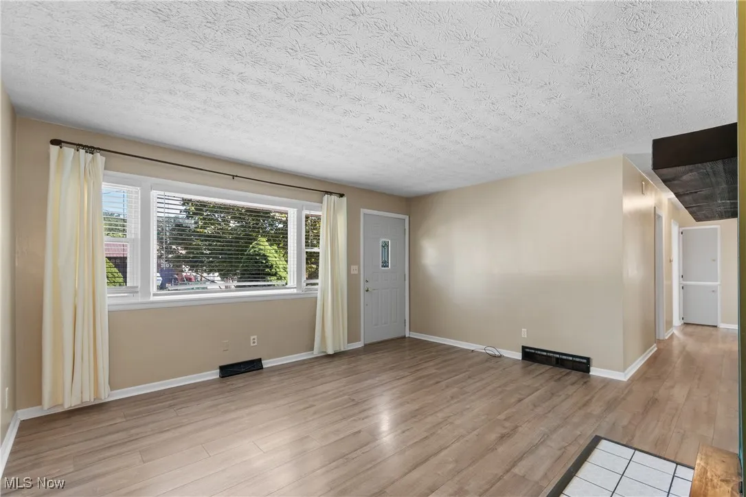Entrance foyer with light wood finished floors and a textured ceiling