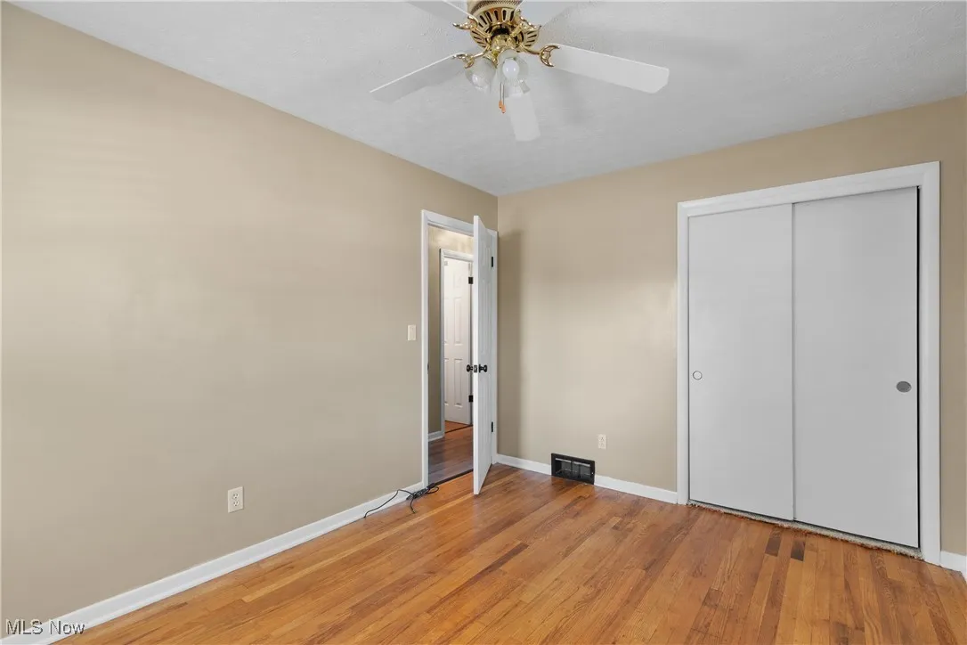 Unfurnished bedroom featuring light wood-style floors, a closet, and ceiling fan