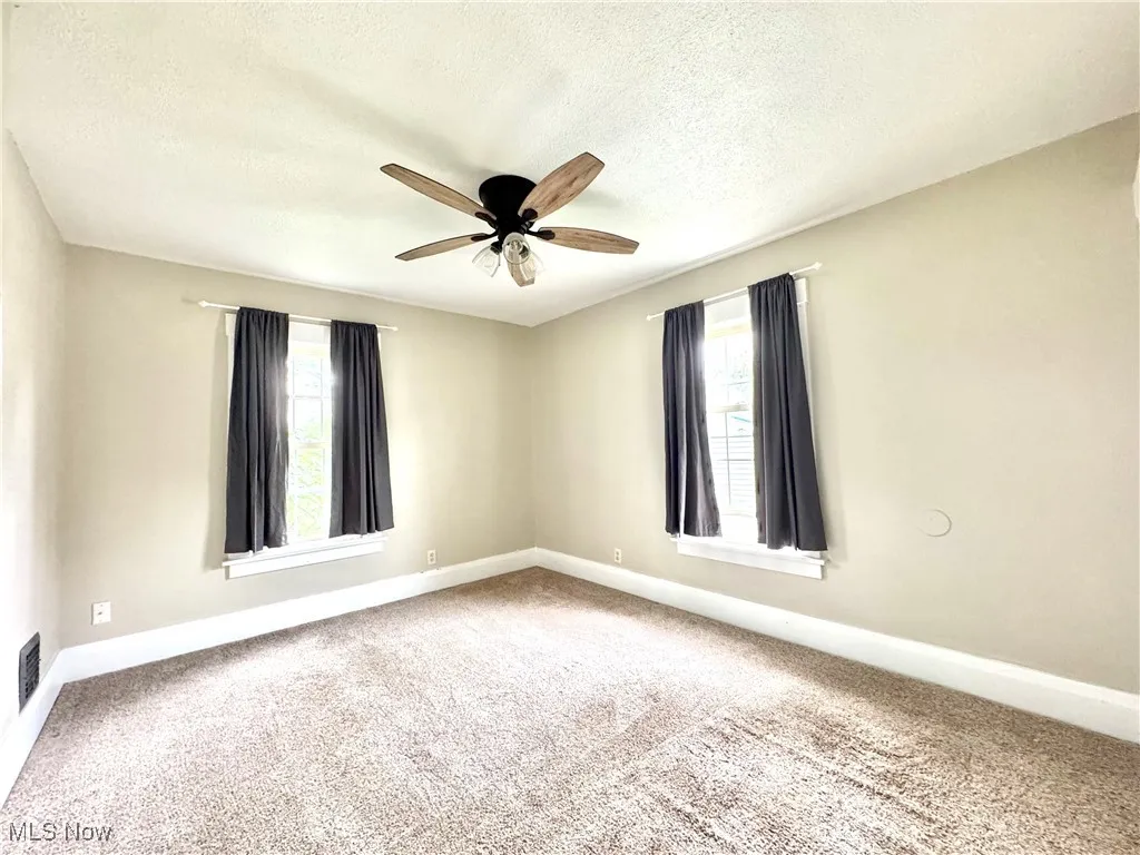 Spare room with carpet, a textured ceiling, and ceiling fan
