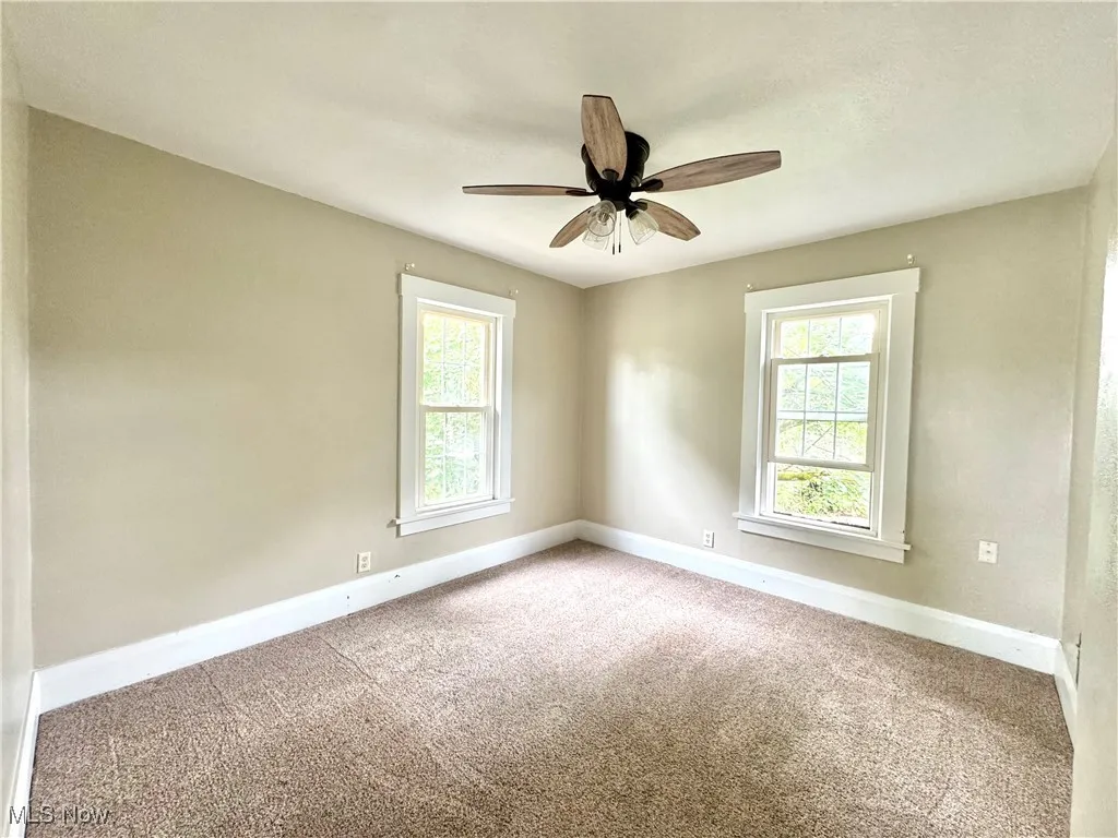 Spare room featuring carpet flooring and ceiling fan