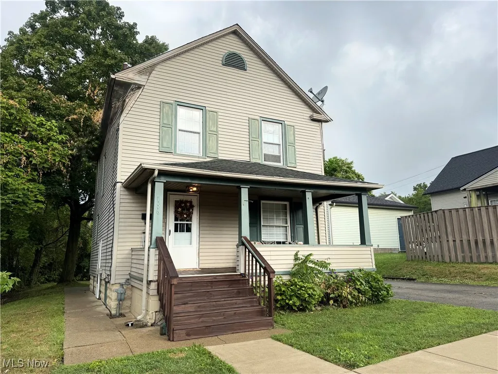 View of front of property featuring a porch and a front yard