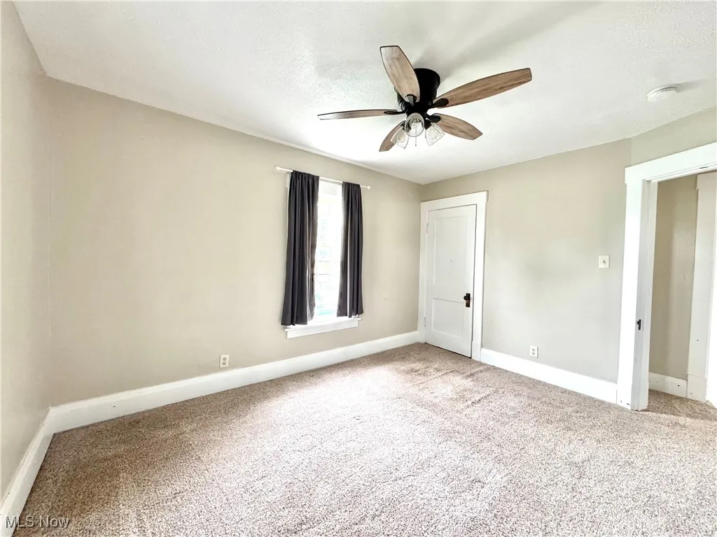 Unfurnished bedroom with carpet flooring, ceiling fan, and a textured ceiling