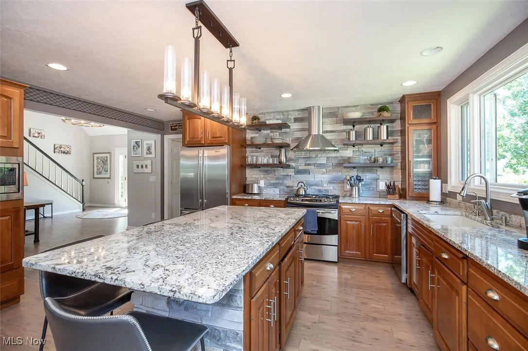 Kitchen with open shelves, stainless appliances and granite countertops