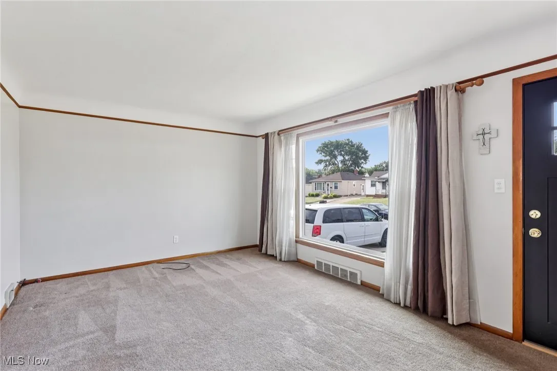Spare room featuring baseboards and light colored carpet