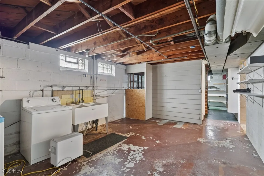 Below grade area featuring a sink and separate washer and dryer