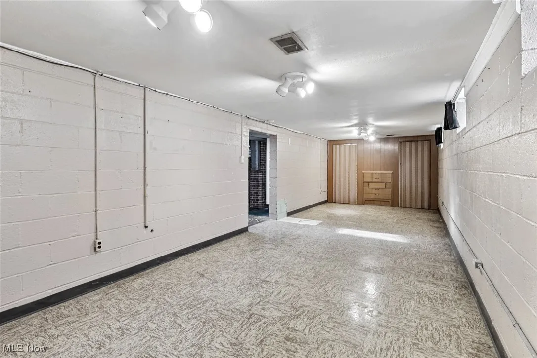 Finished below grade area with tile patterned floors and concrete block wall