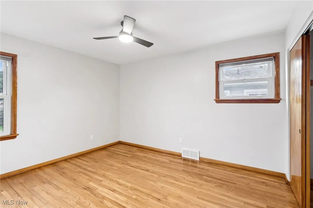 Empty room with light wood finished floors and ceiling fan