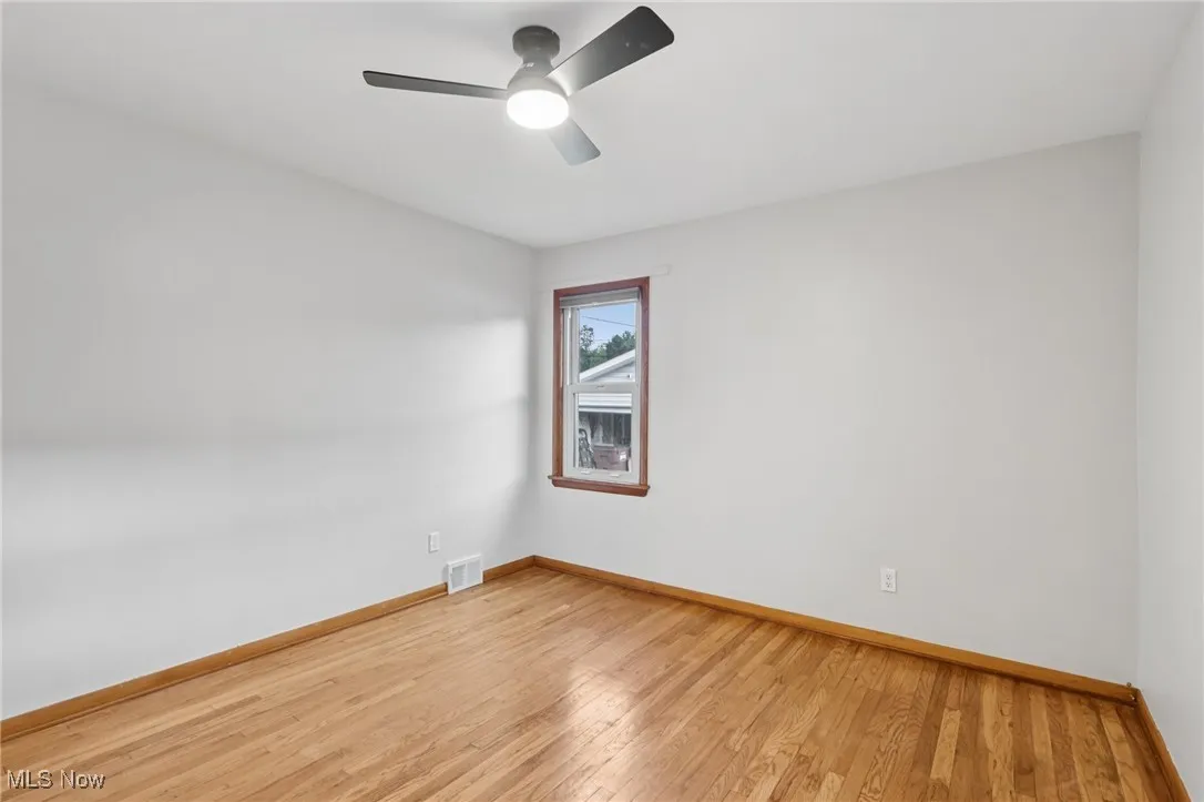 Unfurnished room with light wood finished floors and ceiling fan