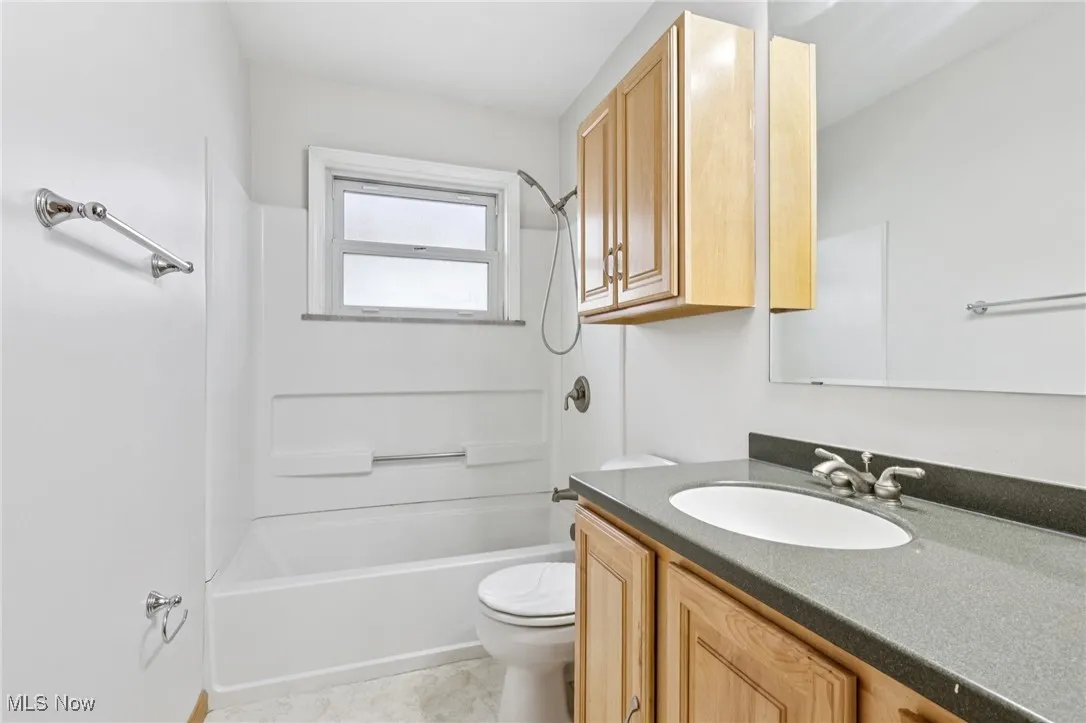 Bathroom featuring vanity, bathing tub / shower combination, and light tile patterned floors