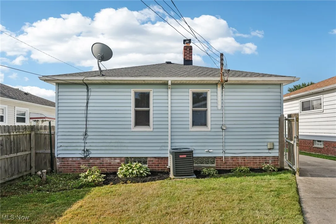 Rear view of property featuring a chimney, crawl space, and roof with shingles